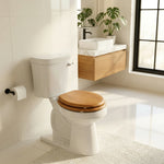 Topseat Natural Oak round wood toilet seat with closed lid in a bright modern bathroom